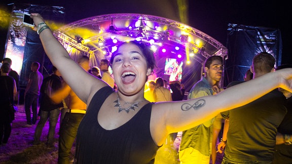 Junge Frau tanzt auf einem Festival