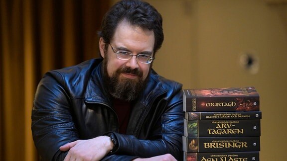 Der Autor Christopher Paolini posiert mit seiner Buchreihe "Eragon".