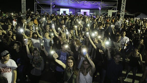 Das tanzende Publikum hält viele Smartphones mit aktivierter Taschenlampe in Richtung Kamera