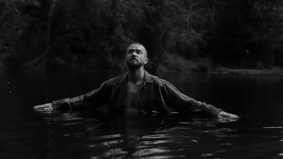 Justin Timberlake mit ausgebreiteten Armen in einem See
