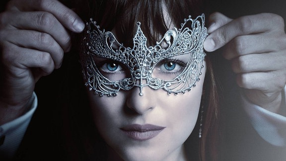 Filmplakat von "Fifty Shades of Grey 2 - Gefährliche Liebe". Mann setzt Frau eine Augenmaske auf.