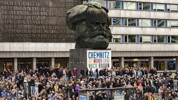 Demonstranten unter den Karl Marx Kopf in Chemnitz 