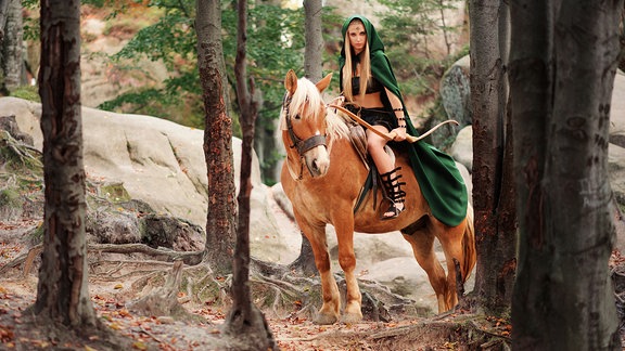 Elbin auf Pferd im Wald