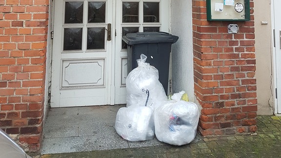 Müllsäcke und Mülltonne vor einer Haustür in Gardelegen
