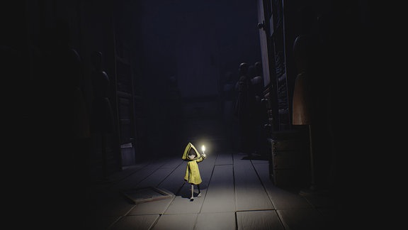 Ein kleines Mädchen im gelben Regenmatel läuft mit einer Kerze in der Hand durch die Dunkelheit. (Spielszene)
