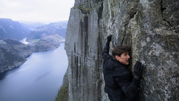 Tom Cruise hängt an einer Felswand (Filmszene)