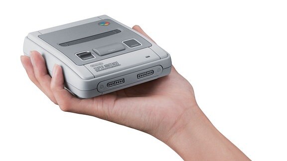 Eine Hand hält ein Nintendo SNES Mini.