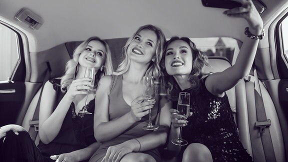 Drei Mädels machen in einer Limo ein Selfie
