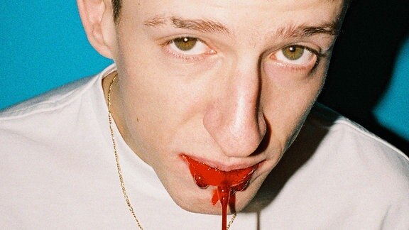 Albumcover: Aus dem Mund eines jungen Mannes scheint Blut zu tropfen.