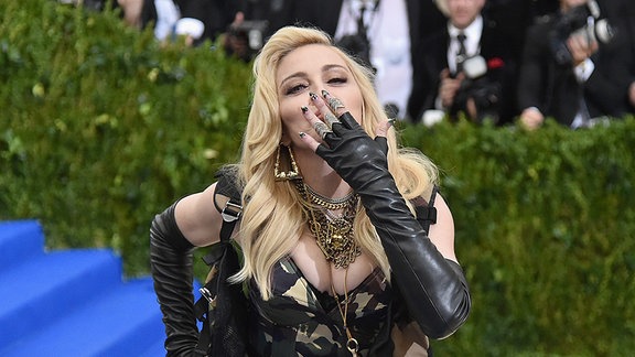 Madonna wirft mit einer Kusshand.