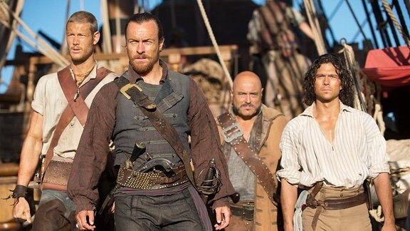 Serie Black Sails, vier Piraten stehen in einer Gruppe auf einem Schiff