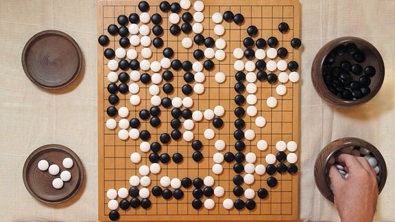 Spielbrett für das Spiel Go mit 19 mal 19 Knotenpunkten und weißen und schwarzen Spielsteinen