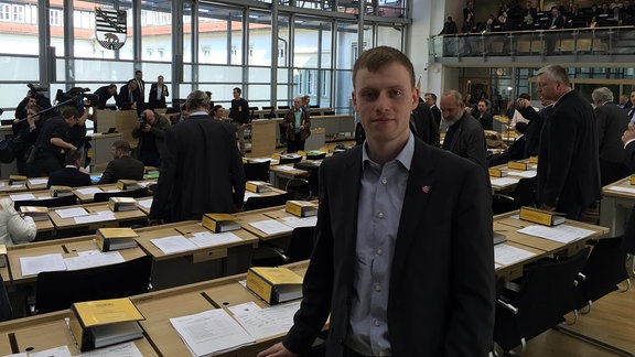 Ein junger Mann im Anzug im Landtag von Sachsen-Anhalt.